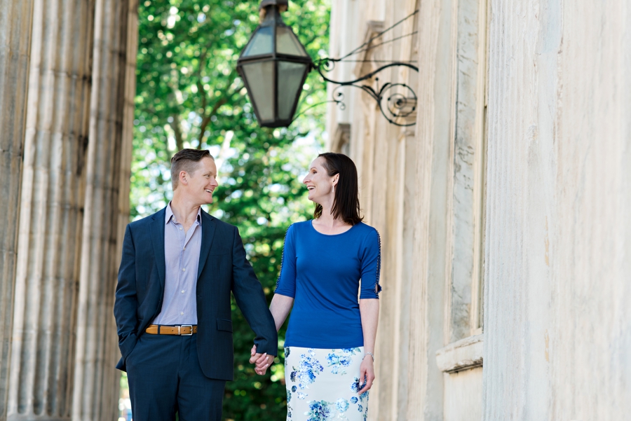 A Couple hold hands and walk in old city.